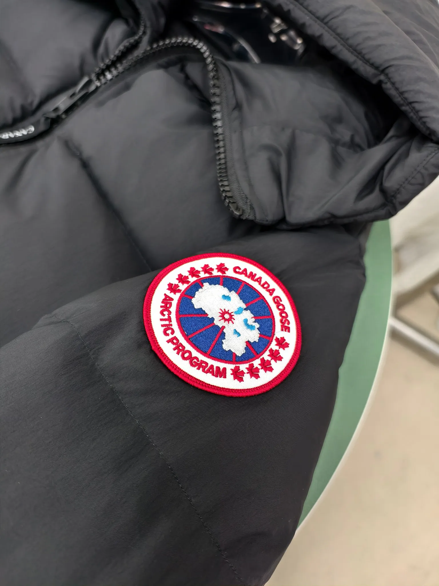 P940 Canada Goose Lawrence Down Jacket The Lawrence Down Jacket provides essential protection for everyday adventures and is made from sustainable Enduraluxe fabric with a durable soft touch. It features a quilted body, an adjustable down hood and a longer hem. Adjustable, down-filled, communicated hood. Two-way center front zipper increases range of motion and ventilation. The chin-protecting suede knit stand-up collar is soft and extra-comfortable. Inset rib-knit cuffs for added comfort and locked in heat. CORDURAD piping at the cuffs hem and reflective double-stripe grip tape at the back. Internal shoulder strap Color: black with red label black with black label azure blue Size: XS-2XL